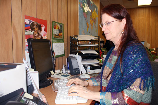 Trisha Tatam checks the status of a student in the Braille certification data base.