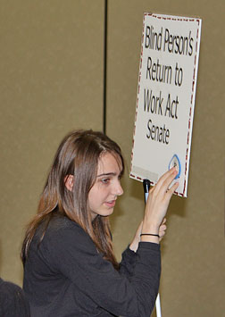 Ashton Dugan reads the number in Braille of cosponsors just added to her group�s sign.