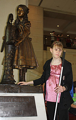 The statue of Helen Keller, age seven, at the water pump is the only child represented in the Capitol rotunda. Kodie Arnold stands beside the statue.