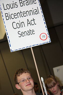 Elliot Parkin, UT proudly holds his Louis Braille Coin Act sign