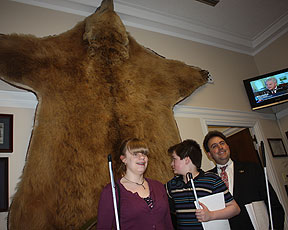 Katelyn Beckman from Minnesota, Dalton Riser from Alaska, and Mark Riccobono from Maryland are shown here as they discuss the Kodiak Brown Bear skin behind them.