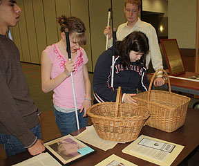 Kodie Arnold and Emily Woods examine baskets woven in sheltered workshops. Mentor Corbb O�Connor and Gabriel Lopez are in the background.
