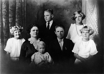 The tenBroek family sitting for a portrait in 1924  From left to right: Ivy (age eight), Marie (mother), Carole (age one), Jacobus (age thirteen), Nickolas (age fourteen), Johanna (age twelve), and Lillian (age nine). 