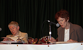 Sharon Maneki (left) and Marsha Dyer reading a resolution on the platform