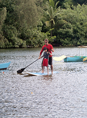 Karlos uses hand-over-hand technique to guide Petras on proper paddling technique.