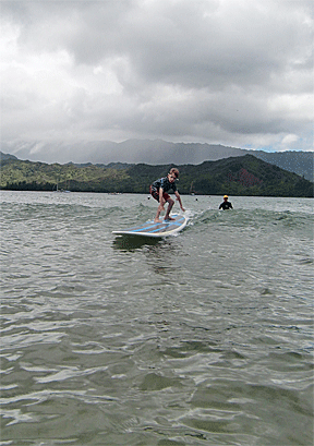 Petras gliding across Hanalei Bay on a surfboard