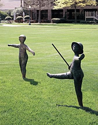 Eight life-size children cast in bronze play on the Hilton Anatole lawn. Two of them are pictured here.