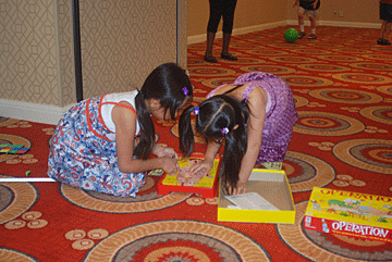 Preschoolers play with games on the floor in an NFB Camp room.