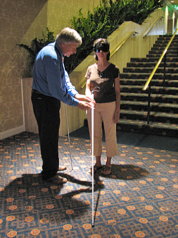 Jeff Altman instructs a woman in how to use a long white cane.