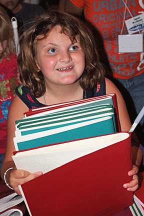 Anna Walker is loaded with Braille books she picked up at the Braille Book Fair.
