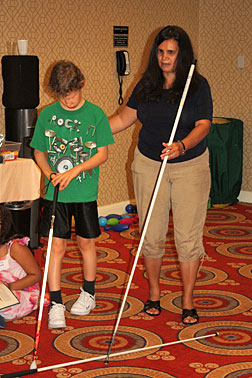 Michelle Chacon (right) helps Andrew Minter with cane travel.