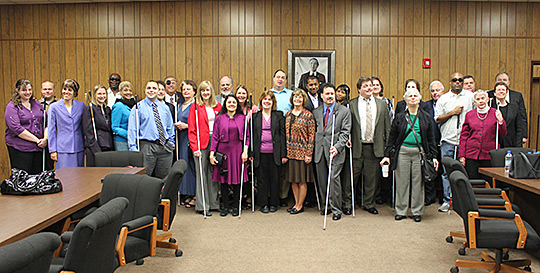 The entire thirty-member committee stands posed in the large conference room where the all-important decisions were made.
