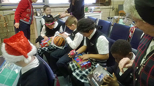 Students at St. Lucy tear into their Christmas presents.