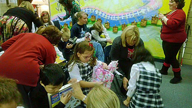 Adult volunteers help with stubborn wrapping paper and packaging as Santa’s gifts are revealed.