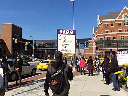 Man with sign protesting low wages at Johns Hopkins.