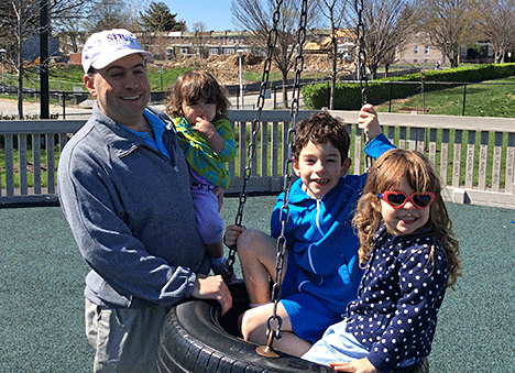 Mark Riccobono, holding his daughter Elizabeth, is ready to push Austin and Oriana on the tire swing.