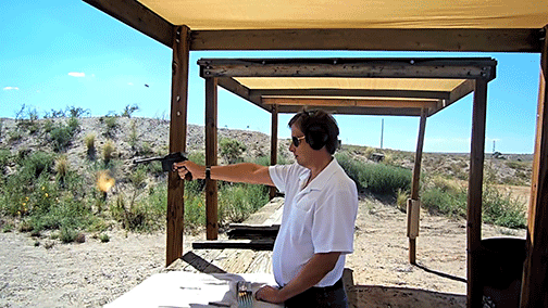 A man fires a gun at a shooting range.