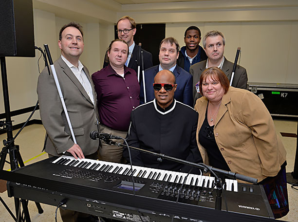 Six Federationists pose with Stevie Wonder after his concert. Next to Stevie on the right is Jenivieve White; behind them from left to right are Mark Riccobono, Tony Olivero, Ryan Jones, Chris Danielsen, Amari Lewis, and Scott White.