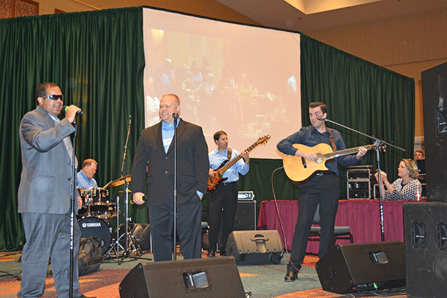 James Brown (center) smiles as Richie Flores (far left) sings along with the band.