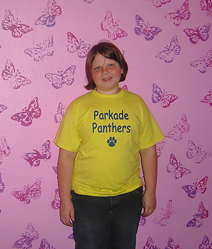 Abbey Houchen stands next to the butterflies her mother painted for her