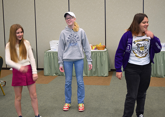 Kaylee Nielson, Kay Mayle, and Adia Berry perform a skit about leadership.