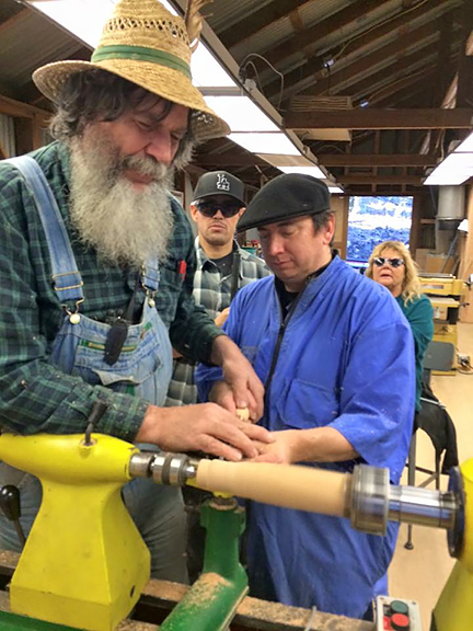 George teaches a student how to use a lathe.