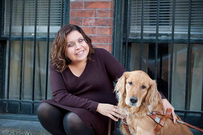 Danielle Trevino smiles broadly as she sits beside her guide dog, Katie.