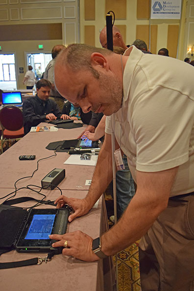 Mike Tindall, a Federationist who works for HumanWare, demonstrates the BrailleNote Touch in the exhibit hall.