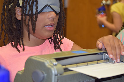 Cassie reads what she just wrote on the Braillewriter at the Baltimore BELL Academy.