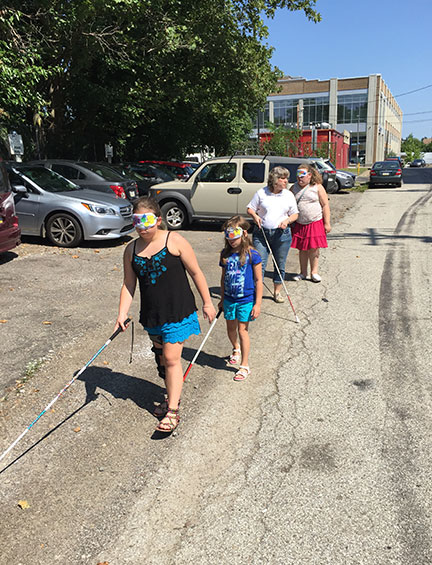 Adison, Jazmin, Meridian, and Miss Michelle cross the street in their learning shades.