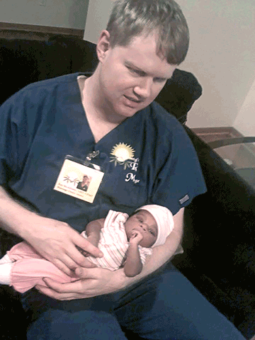 Ray McAllister cradles a newborn baby girl he helped deliver.