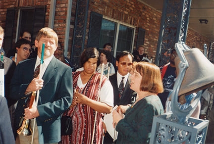 Jerry Whittle and others stand in the courtyard of the Louisiana Center for the Blind next to the Freedom Bell. 