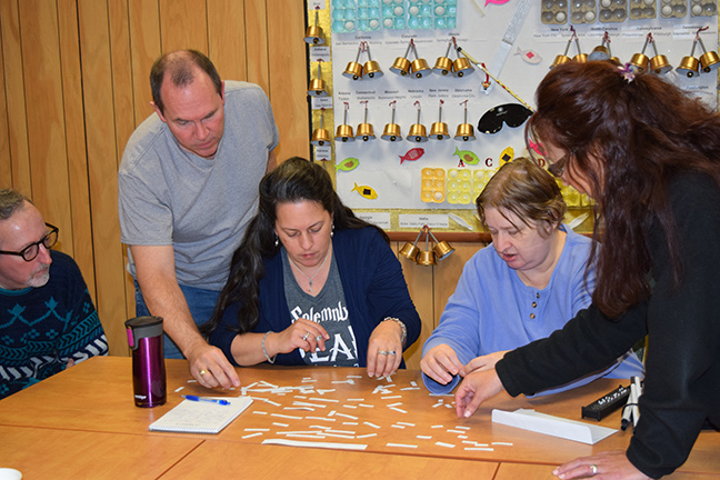 Left to right: Joe Miller, Bob Watson, Tammy Albee, Shelley Duffy, and Susan Skaarer work on assembling words into the one-minute message.
