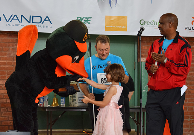 Oriana Riccobono presented the Baltimore Oriole with a plaque thanking the mascot for the team&rsquo;s support of the NFB event.