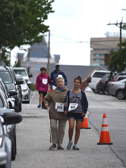 Sharon Maneki walks the course with a sighted guide