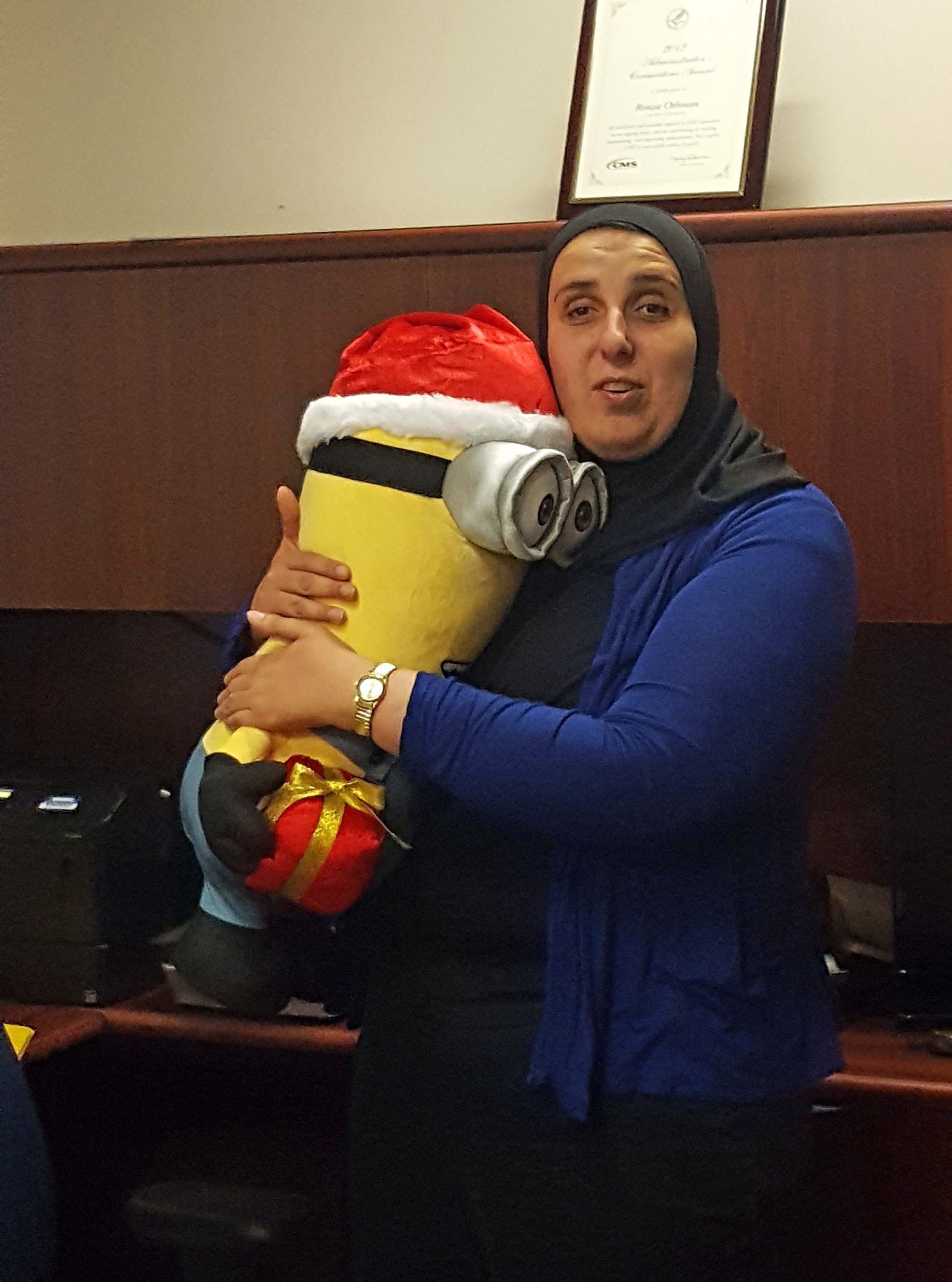 Ronza Othman hugs a stuffed minion from the movie Despicable Me.