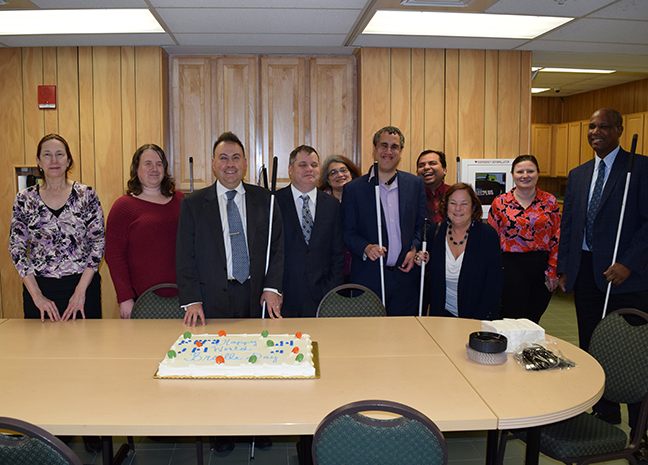 The Jernigan Institute staff pose with the cake for World Braille Day.]