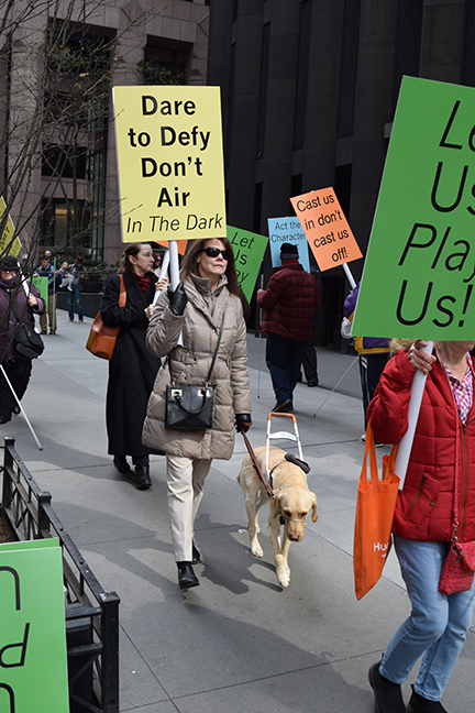 Maryanne Cooney Melley marches with her guide dog at the Let Us Play Us protest