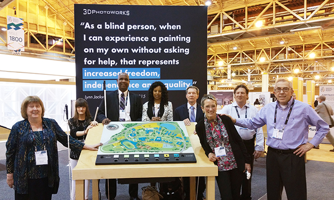 Anil Lewis, John Olson, and others pose with display of a tactile map