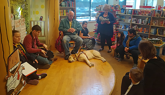 Carole reads a poem aloud during story time reading.