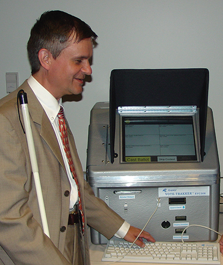 Steve Booth demonstrated one of the accessible voting machines at the Jernigan Institute.