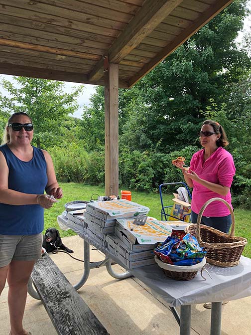 Greater Akron members Jessica Stover and Krissy Coen serve pizza and help students with accessible crafts and games.
