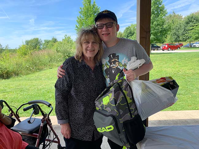 Greater Akron member Pat McPherson gives a backpack of accessible school supplies to a student.