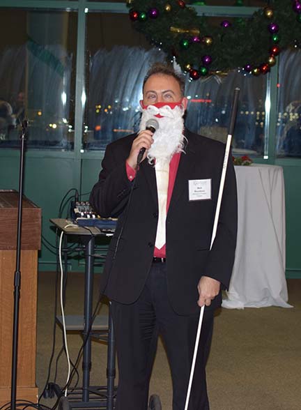 Mark Riccobono wearing a Santa’s beard addresses the crowd.