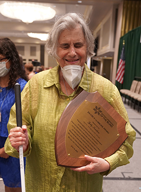 Judy Sanders holding her Jacobus tenBroek Award.