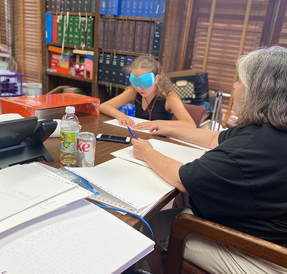 Student with mentor at table doing a Braille lesson during the New Jersey BELL Academy.