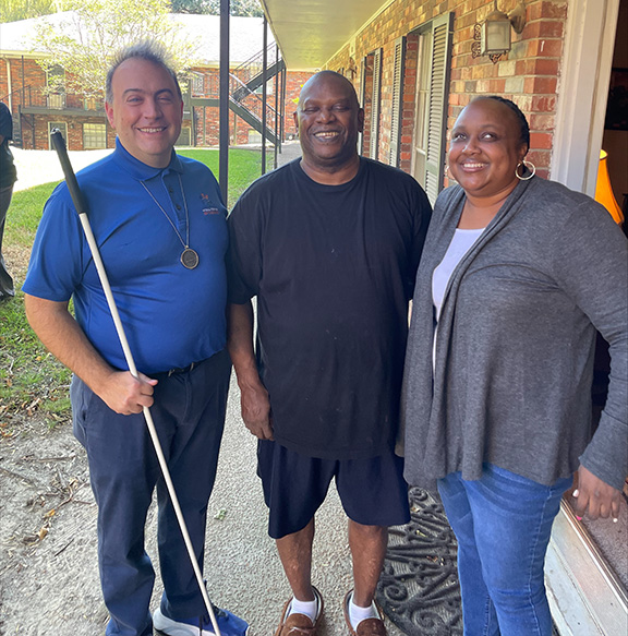 Mark Riccobono poses for a picture with LaShawna Fant and Al, a member of the NFB of Mississippi, Jackson Chapter.