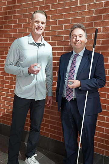 Dan O&rsquo;Rourke and Mark Riccobono smile and hold their NFB member coins.