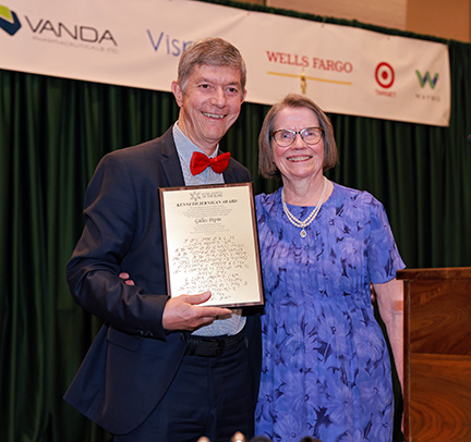 Gilles Pepin and Mary Ellen Jernigan smile together. Gilles holds his award.