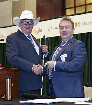 Vernon Humphrey and Mark Riccobono smile and shake hands.